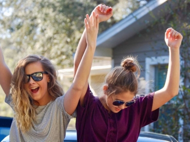 Happy teenage girls dancing outside