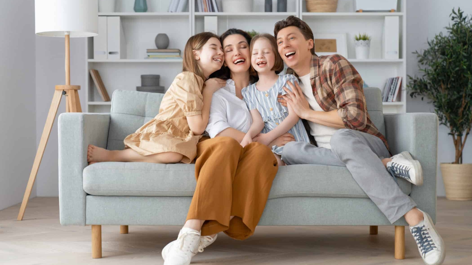 Happy family! Two children daughters with mother and father. Mum, dad and girls laughing and hugging.