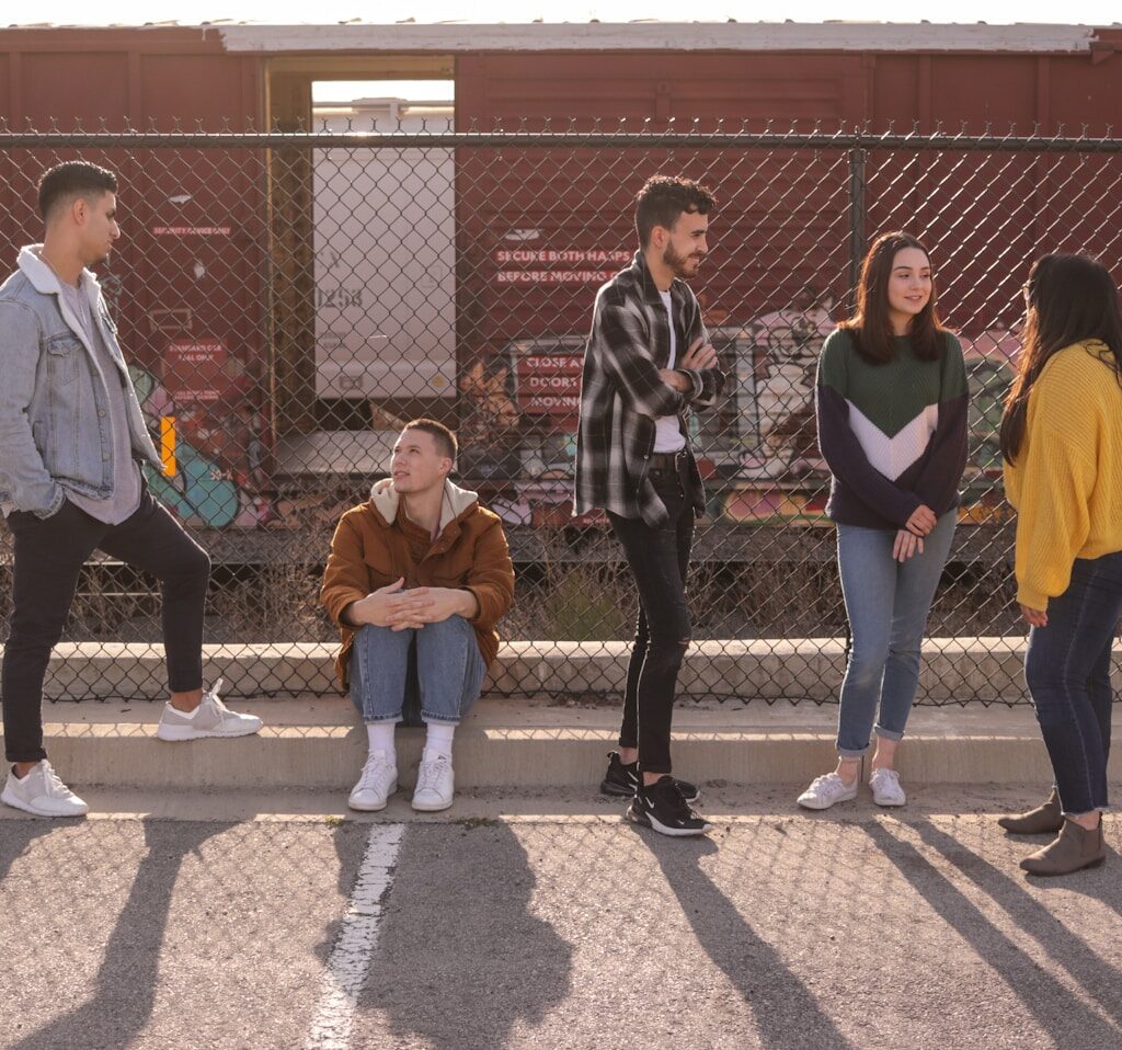 five persons on front of chain link fence