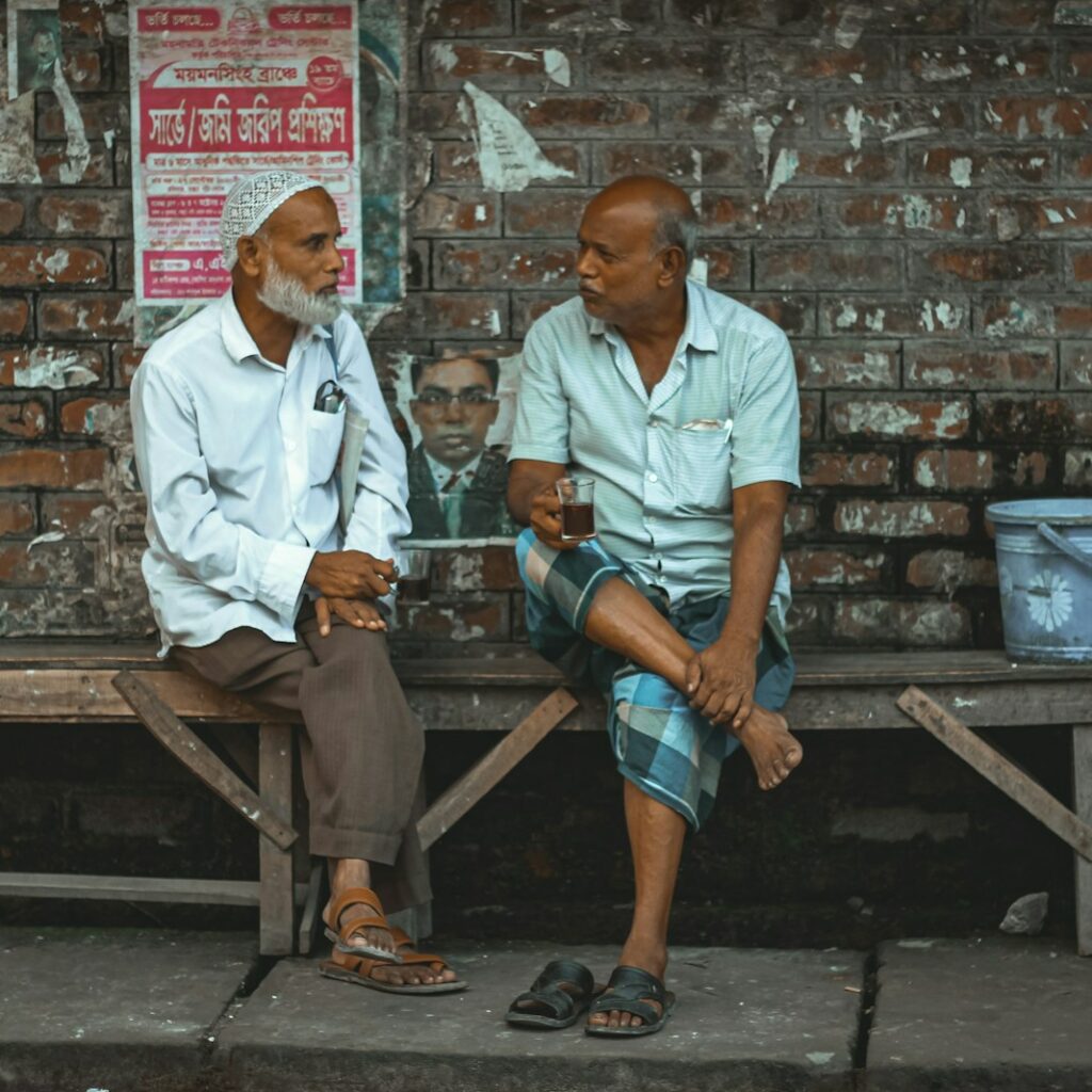 man in white button up shirt sitting on brown wooden bench