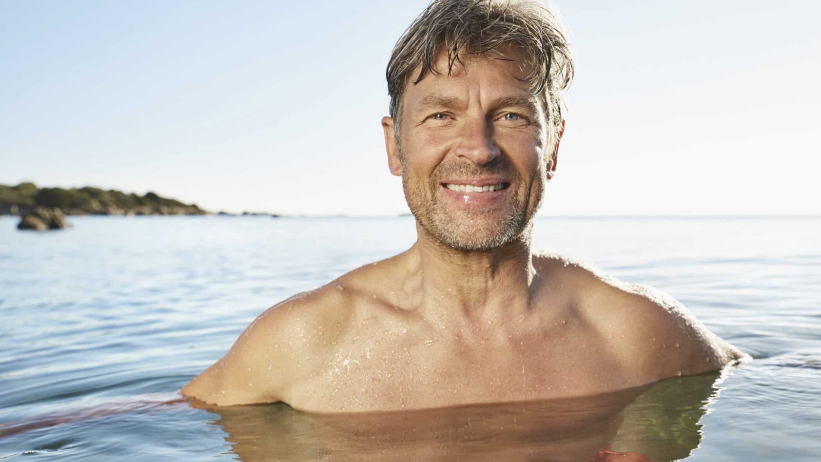 Portrait of smiling man bathing in the sea