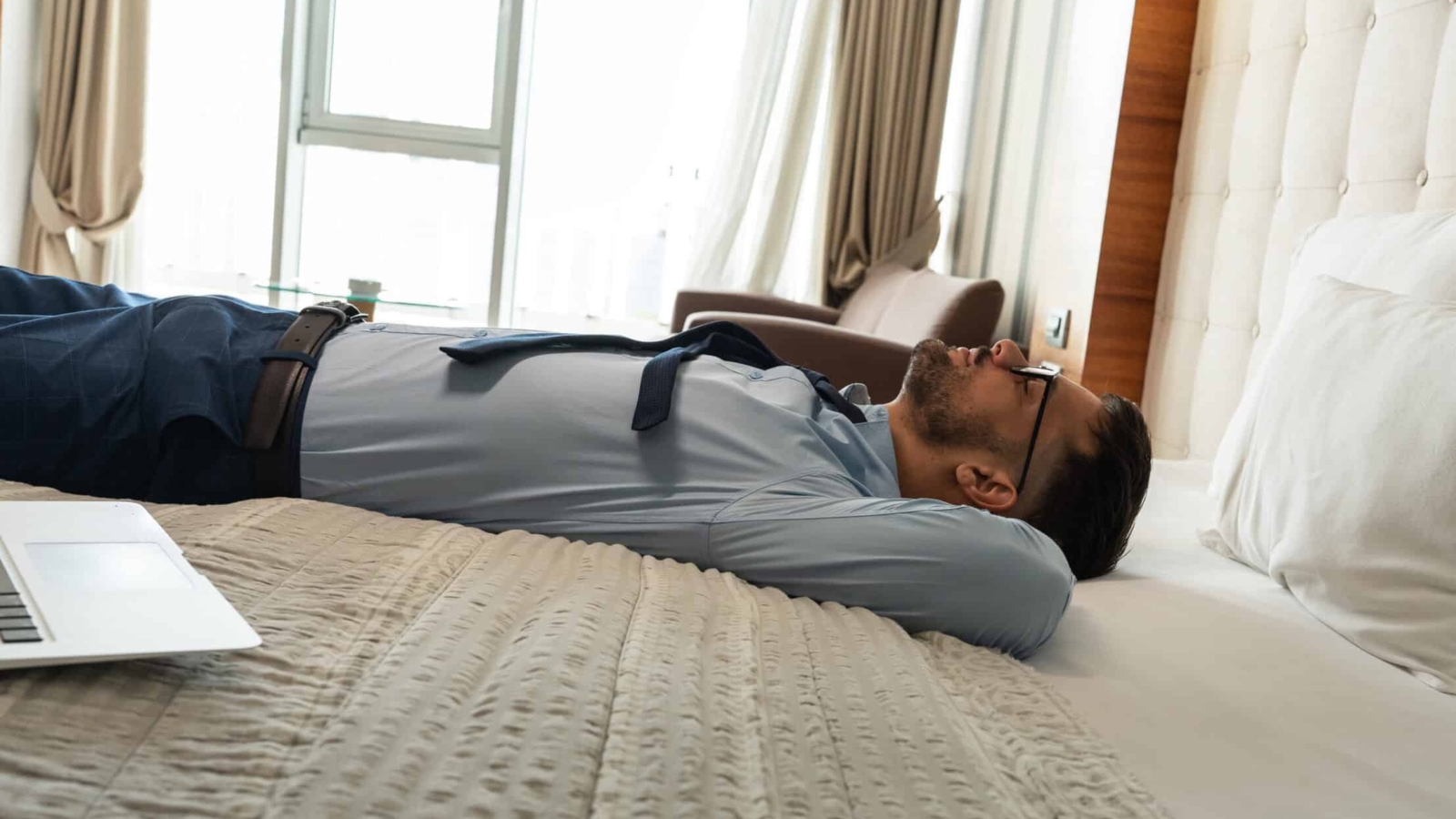 tired-business-man-lies-on-hotel-bed-2026-03-20-02-06-49-utc