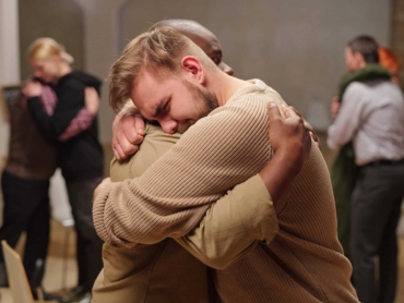 Two young intercultural man embracing while one of them crying