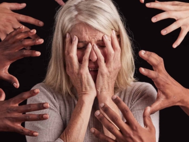 Senior woman, hands or mental health stress on black background in studio with guilt, fear or schiz.