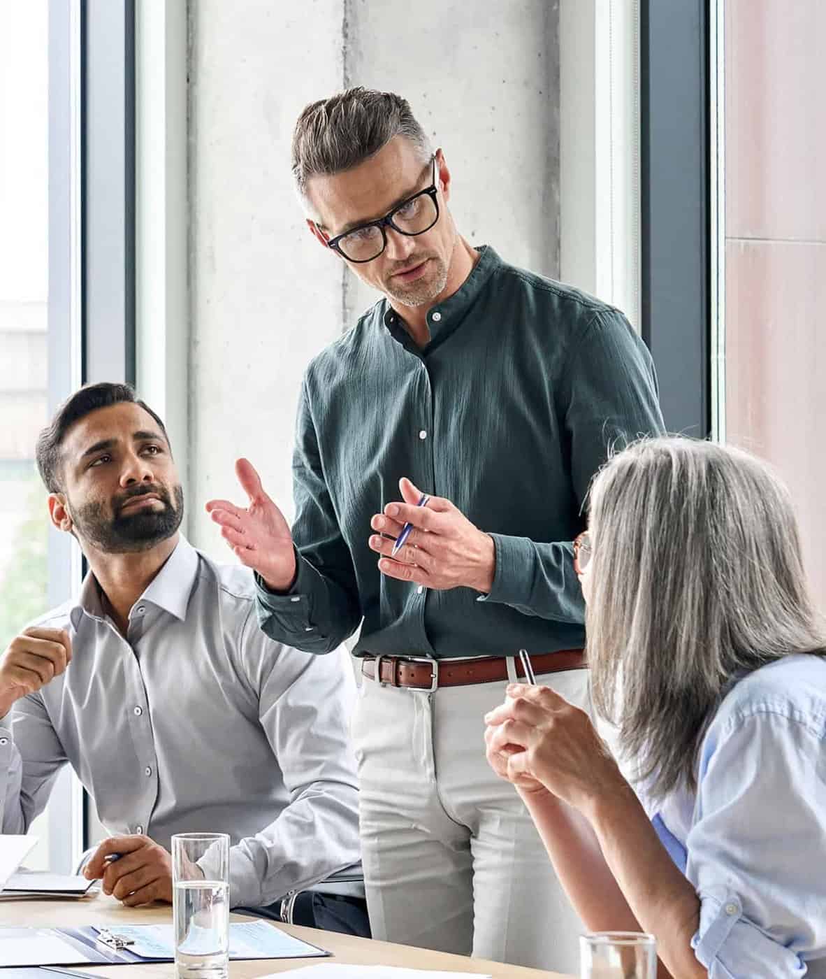 Muž vysvetľuje kolegom svoje stanovisko pri pracovnom stretnutí